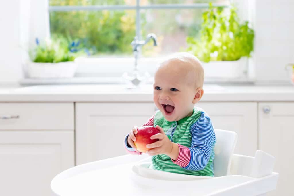happy baby doing baby led weaning in the best high chair for easy clean up